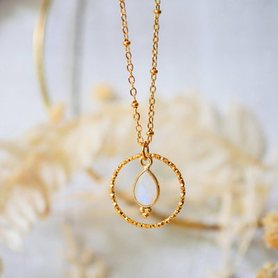 Handgemachte Boho-Edelstahlkette mit Regenbogen-Mondstein-Anhänger auf weißem Hintergrund – Naturschmuck für Frauen