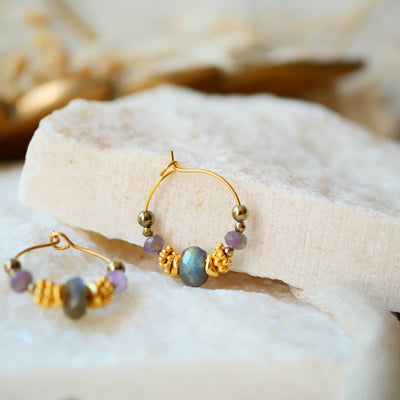 Zwei goldene Creolen-Ohrringe mit Labradorit-Perlen und kleinen violetten Akzenten.