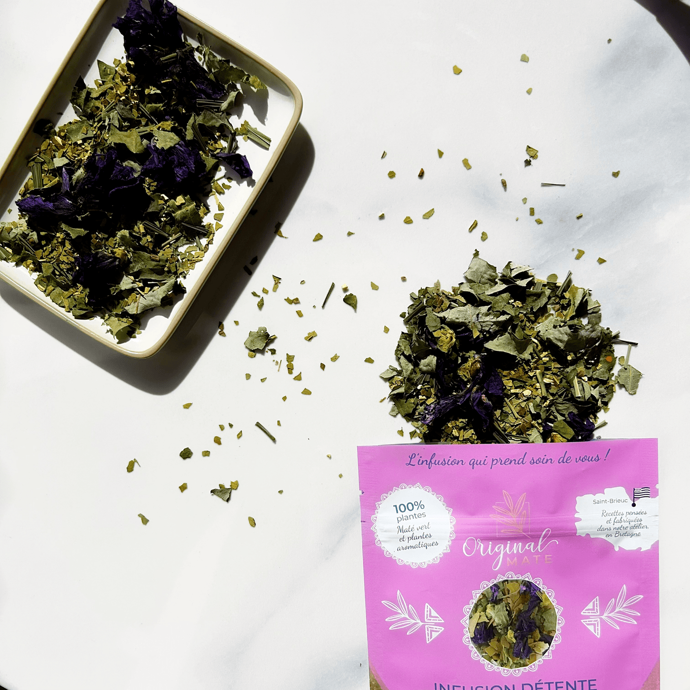 Bio-Mate in Keramiktasse mit Kräutern, stimmungsvolle Naturaufnahme.
