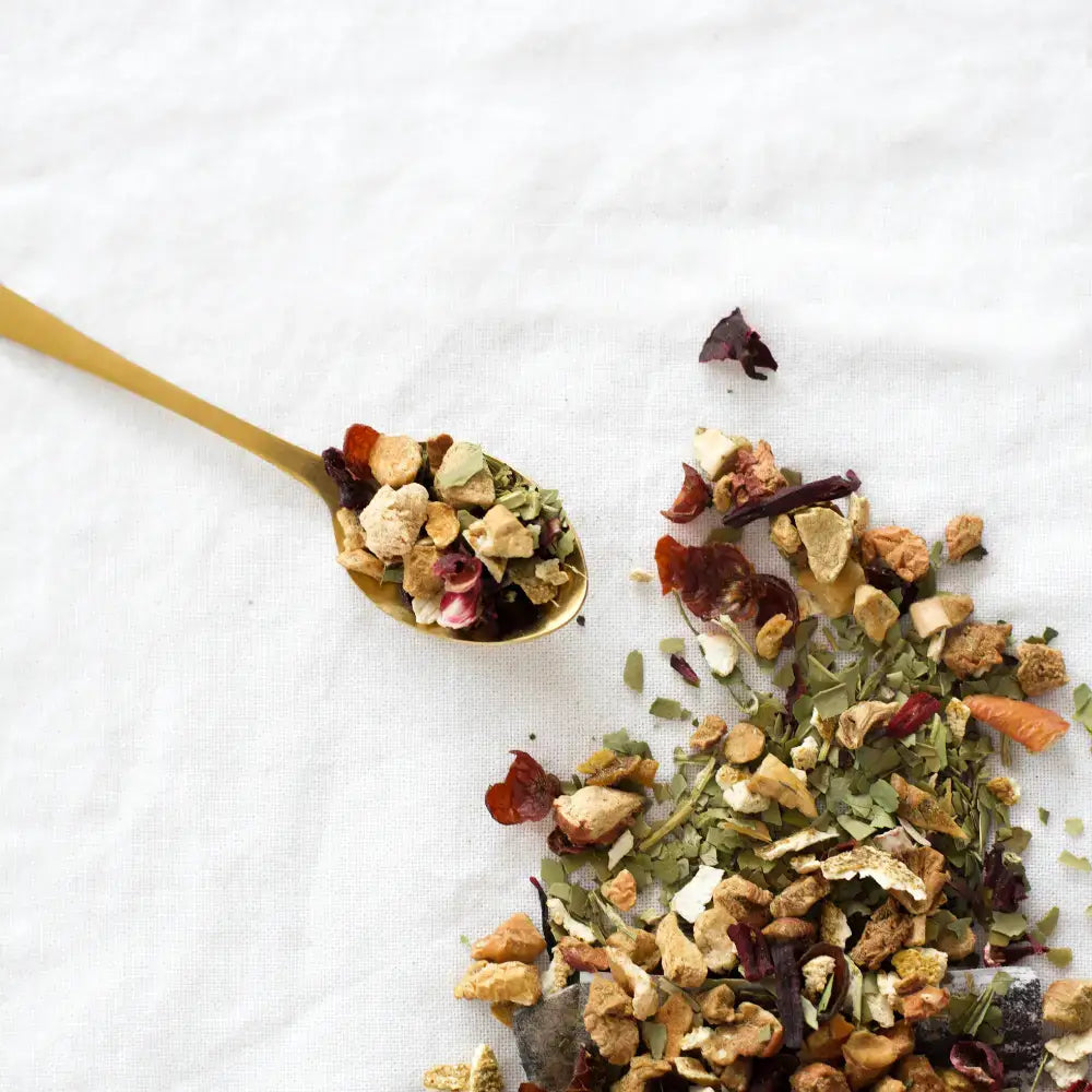 Makroaufnahme der Bio-Mate-Zutaten: grüner Matetee, Mango, Apfel, Hagebutte, Ringelblumenblüten.