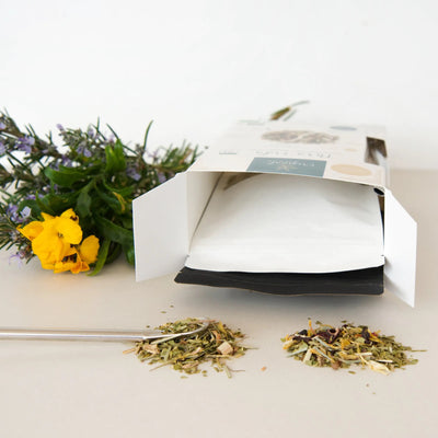 „Mate-Teemischung Pura Vida Día und Noche, ausgegossen vor der geöffneten Verpackung, mit floraler Dekoration.“ - Dianas Klosterlädchen